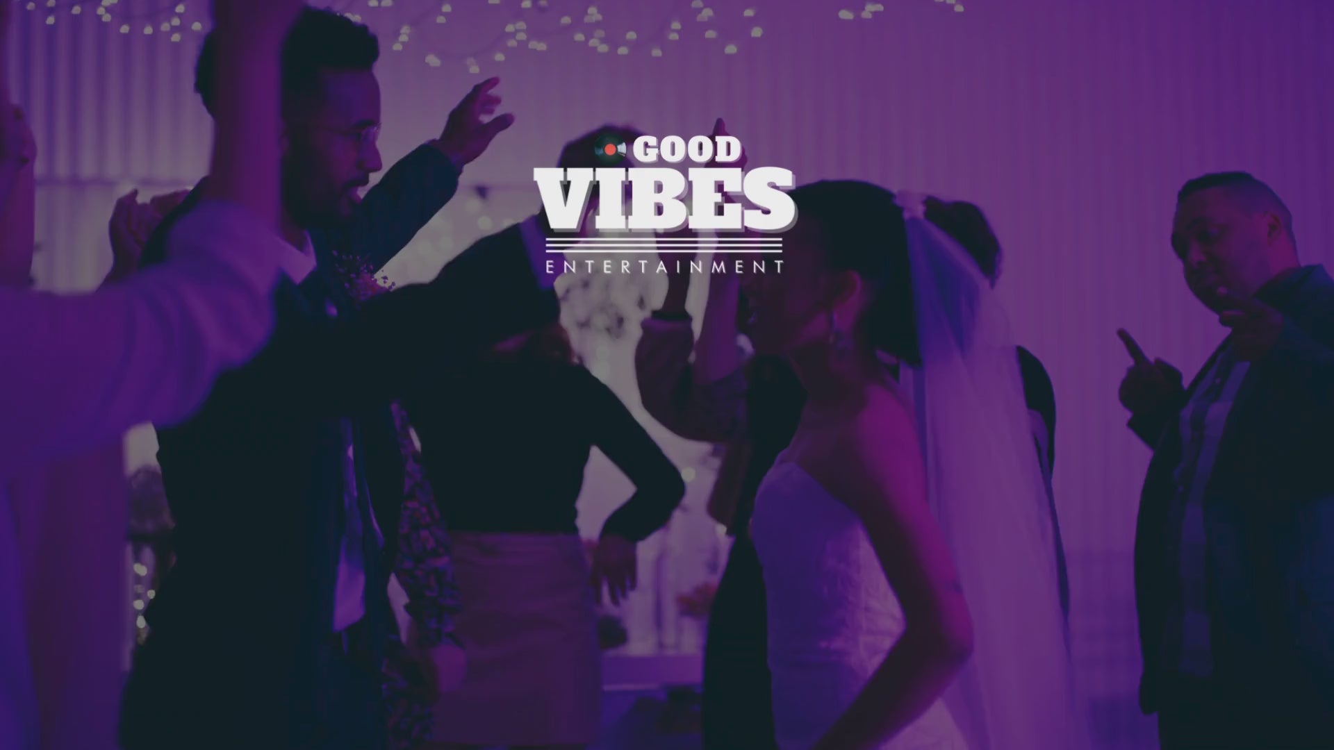 Newlywed couple celebrating and dancing at their wedding along with family and friends on the dance floor.
